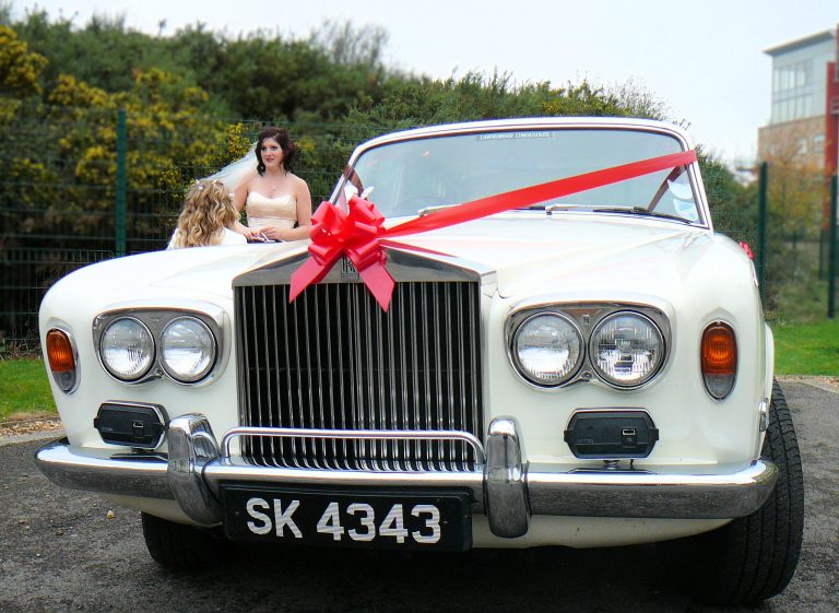Image of bride awaiting by wedding car. Photo by JD Photography Isle of Wight wedding photographer.